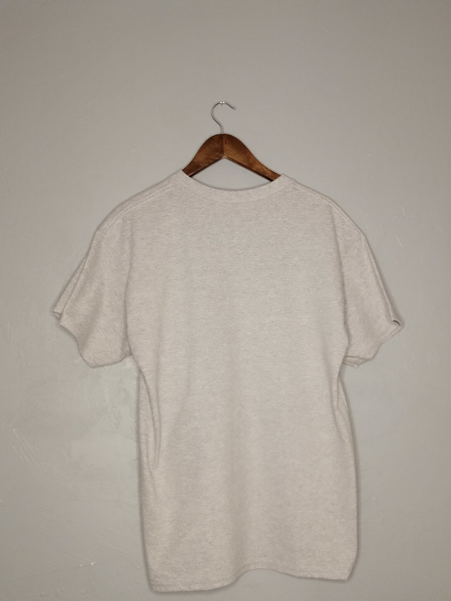 Light gray sweater on a wooden hanger against a plain background back view.