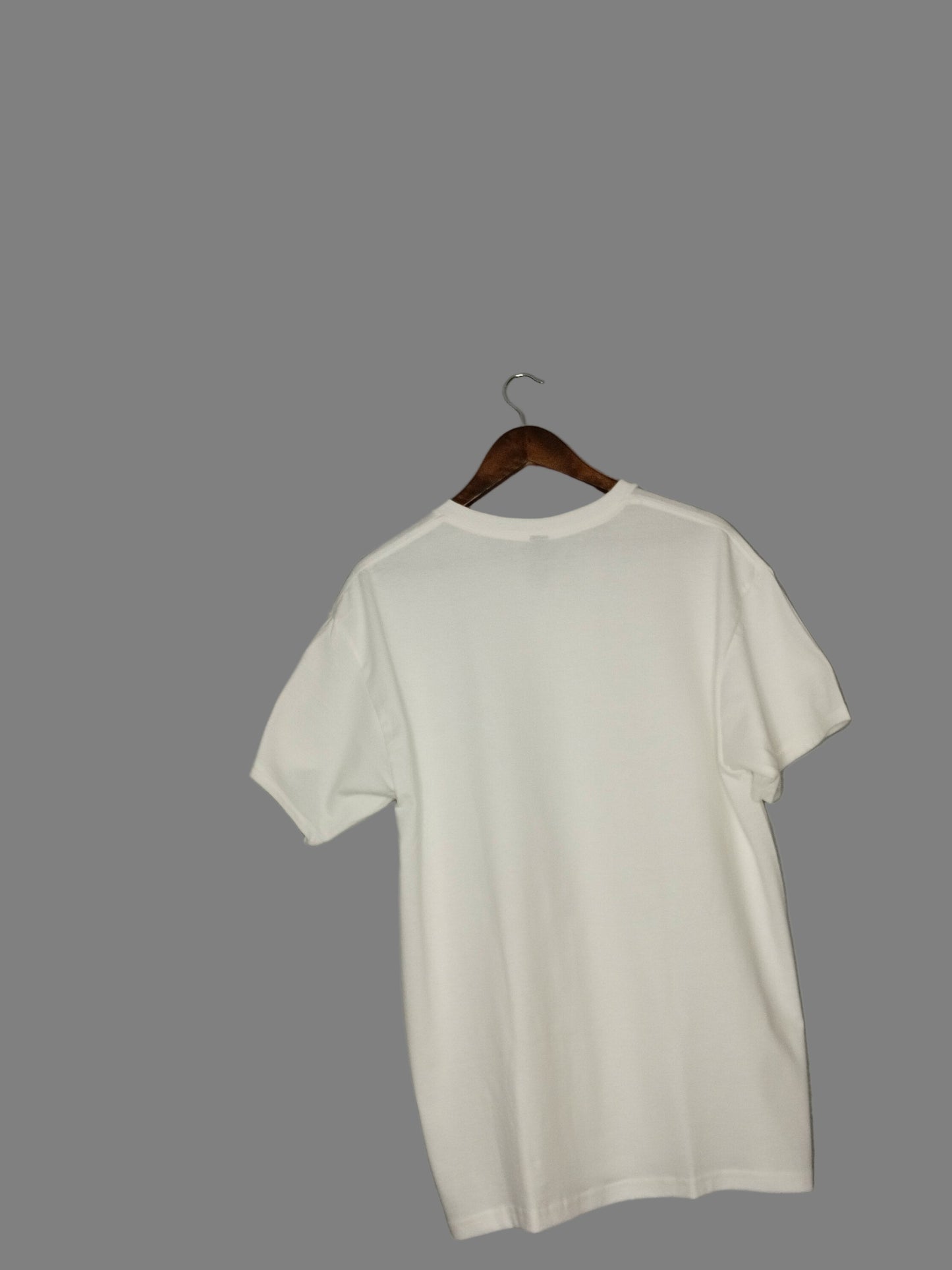 White shirt on a wooden hanger against a gray wall