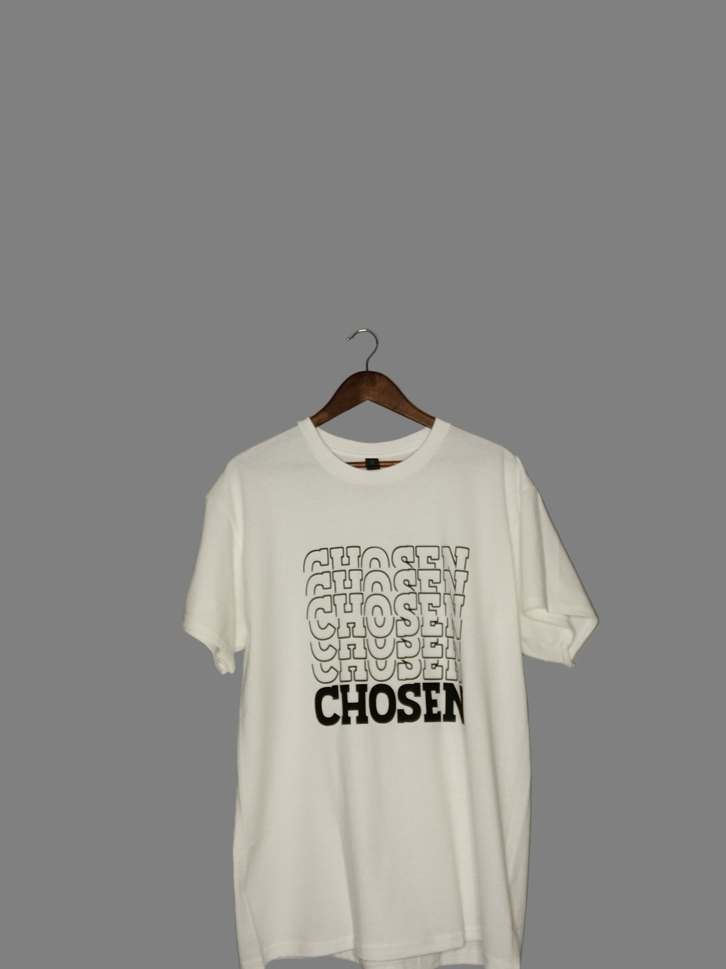 White t-shirt with 'CHOSEN' text on a hanger against a gray background
