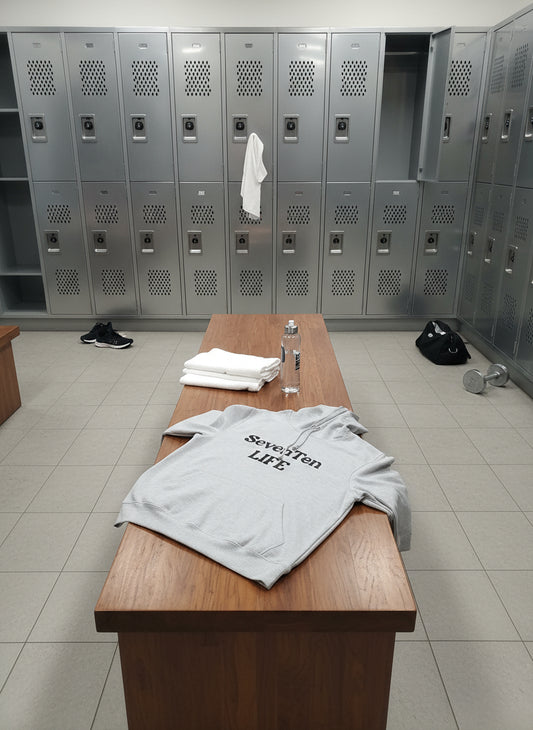 Beige hoodie with 'Seven Ten LIFE' text on a wooden floor